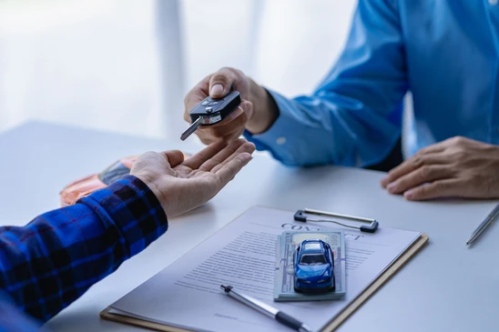 Un concessionnaire automobile ou un directeur de vente propose de vendre une voiture et explique les conditions de signature d'un contrat d'assurance et de voiture