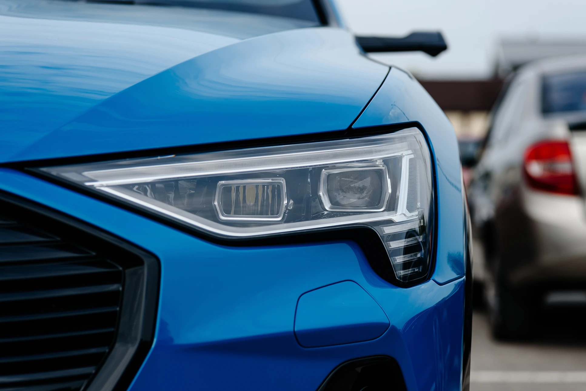 Phare automobile moderne en gros plan sur fond blanc neutre, présenté de trois-quarts avant