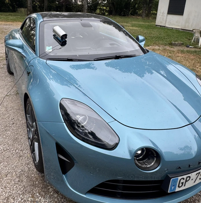 Détail artistique en noir et blanc d'un véhicule automobile de luxe, mettant en valeur le phare avant et les lignes de carrosserie