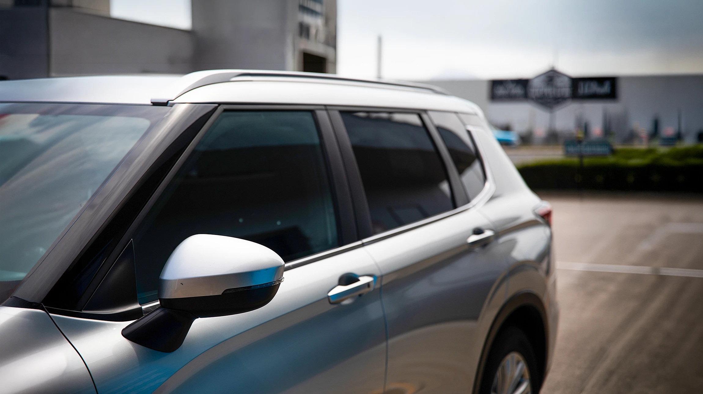 Scène extérieure montrant une voiture rouge avec dégâts visibles sur la portière arrière droite