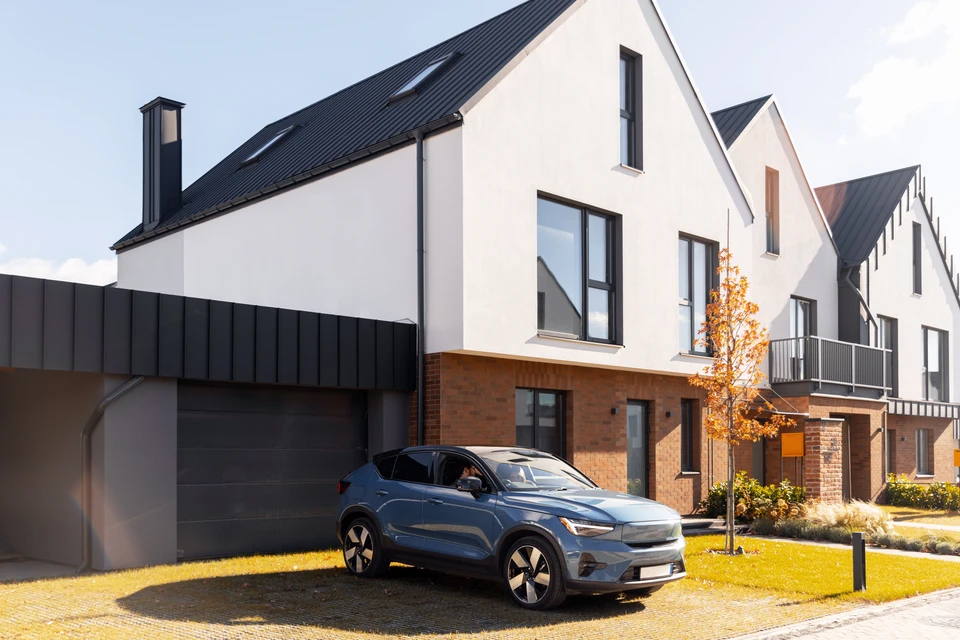 Intérieur d'un garage automobile avec deux véhicules en réparation, une berline grise et une rouge avec capot ouvert