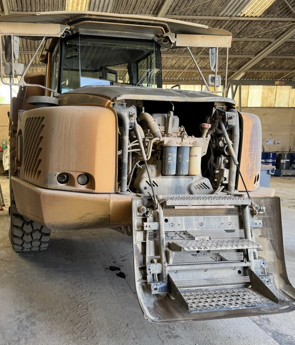 Atelier automobile intérieur avec technicien barbu en bonnet noir travaillant sur vitrage de véhicule gris